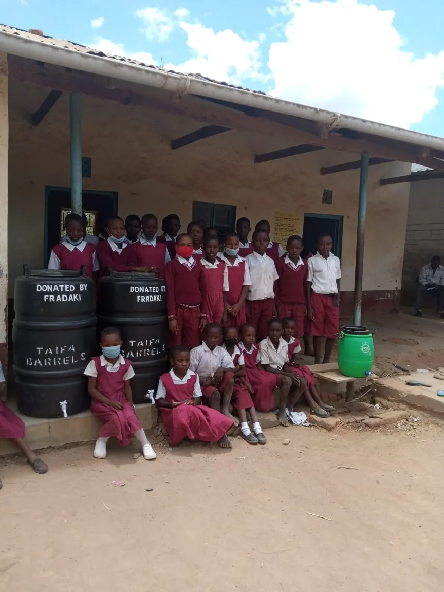 Students in Ngiluni Comprehensive School receive water tanks donated by FRADAKI members.