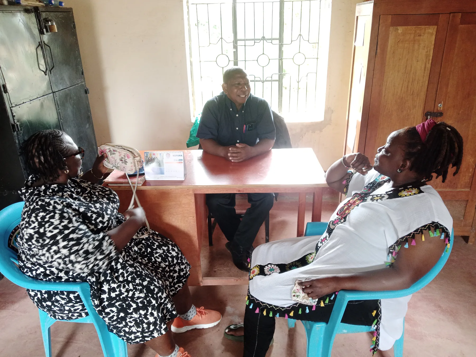 The Headteacher of Ngiluni Primary School,Mr Joseph welcoming the Secretary, Md Sabina Obura and the Founder of Fradaki Mrs Ruth Kalinga in his office to talk about the progress of the students.