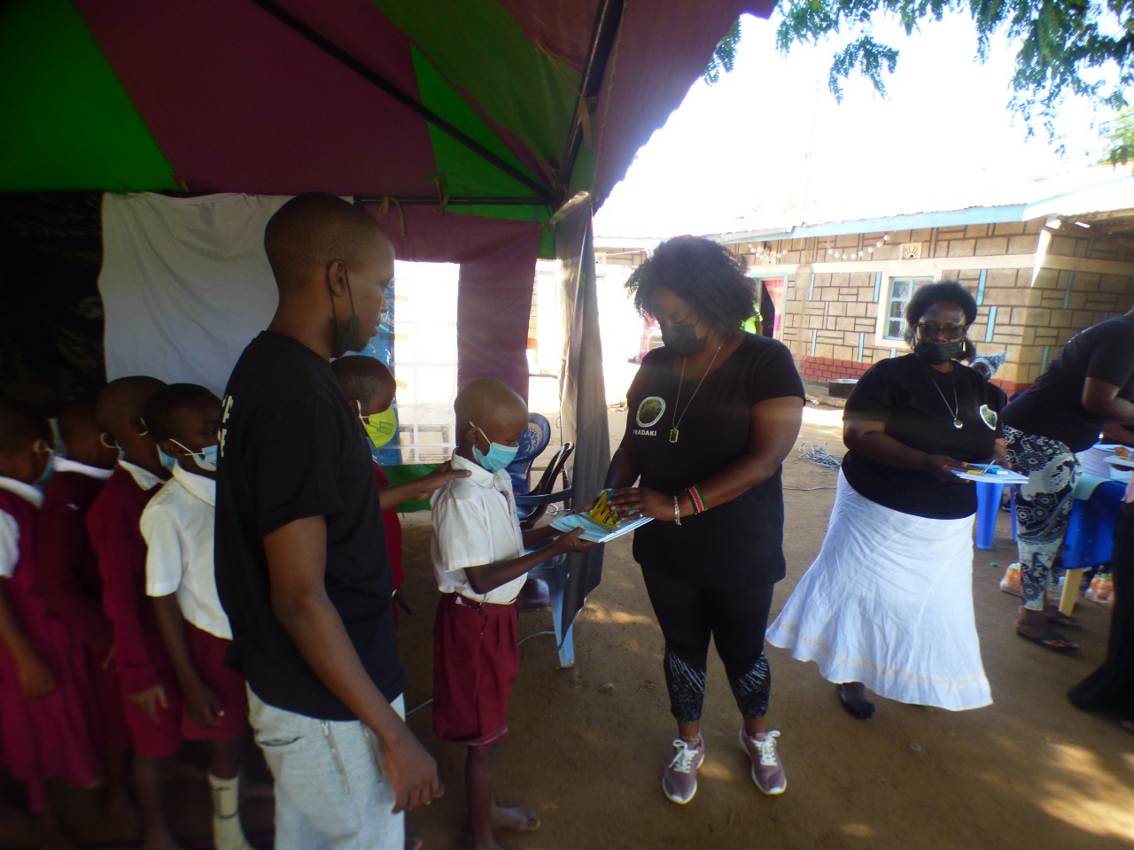 FRADAKI members giving out writng books to the students.
