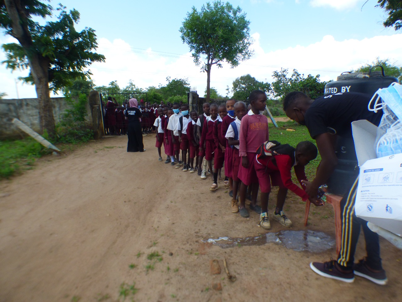 Students of Ngiluni Comprehensive School preparing for a guiding and counseling session by washing hands and wearing face masks. 